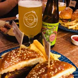 Guava beer bottle and glass with a burger