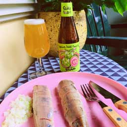 Guava beer bottle and glass with cooked fish