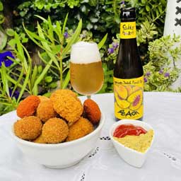 Peach beer bottle and glass with Dutch snacks