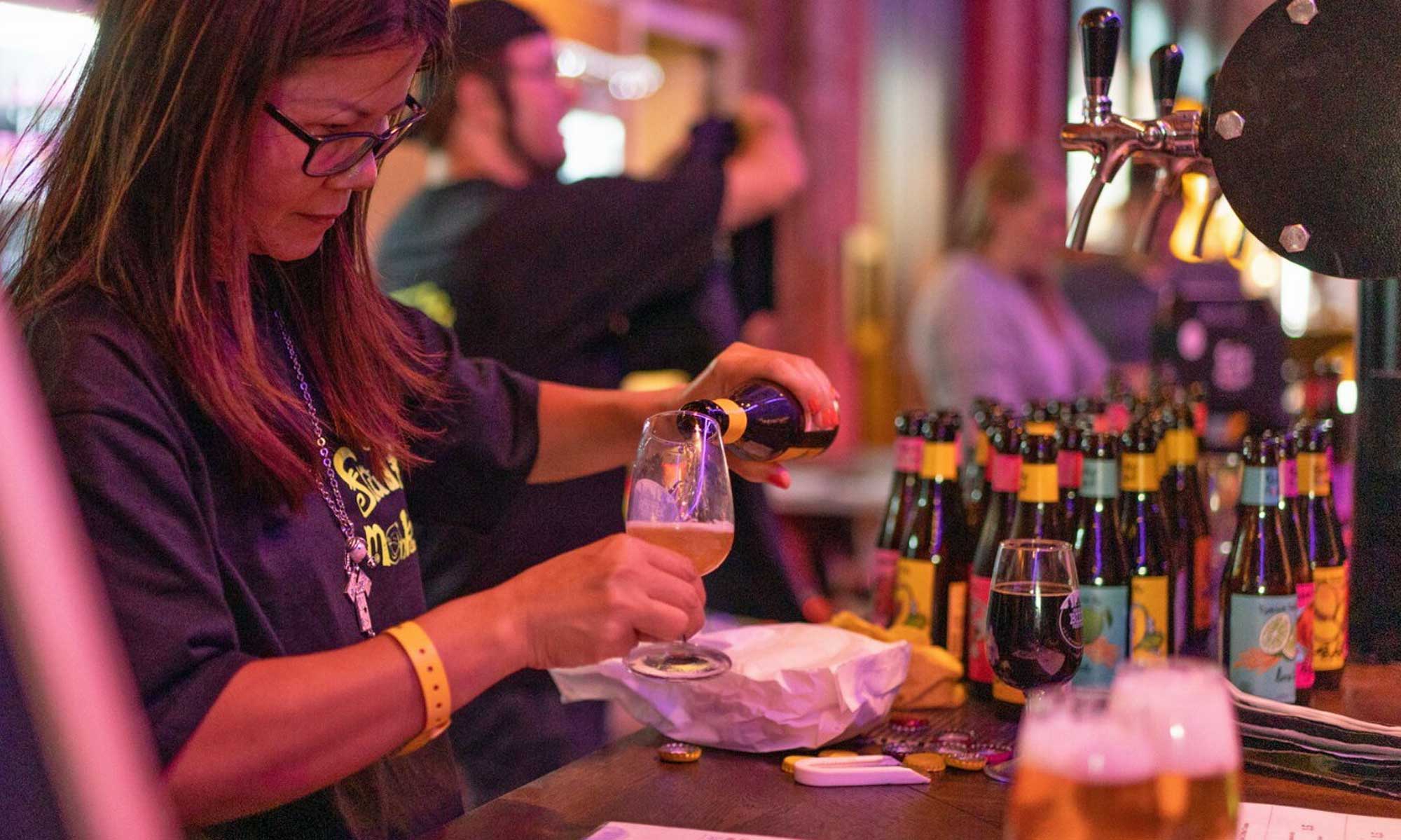 Staff pouring beer at a beer festival.