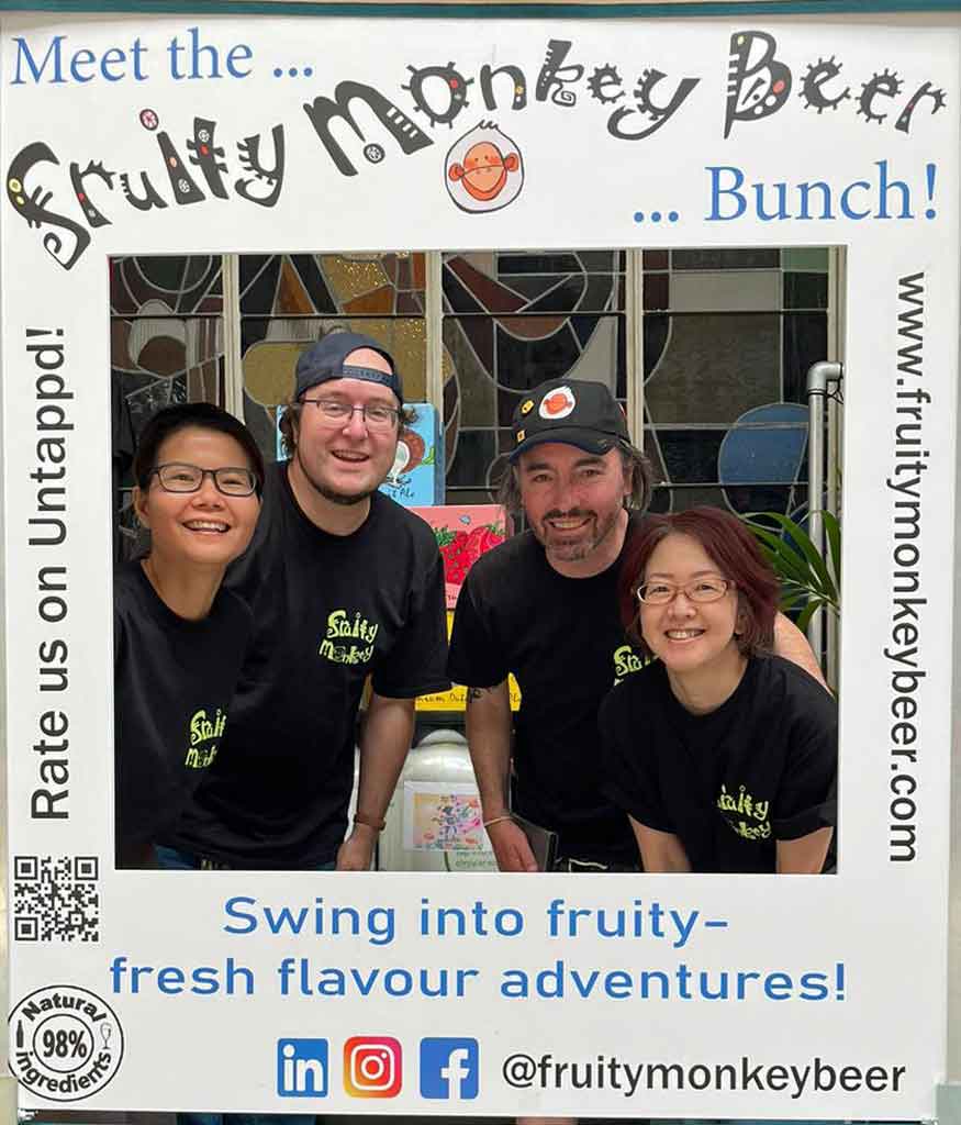 Four people behind a social cutout enjoying top North Holland beer