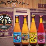 Five fruit beer bottles shown in front of a bottle shop photographed in subdued lighting