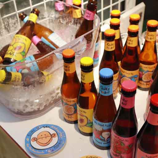 Colourfully labelled bottles of beer, some in an ice bucket.