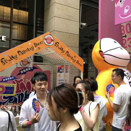 Beer drinkers crowding around a beer stall labelled Fruity Monkey Beer at a festival