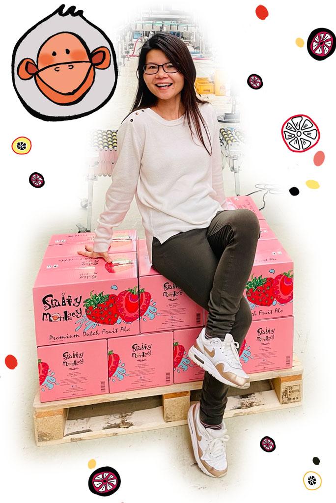 Lady sitting on pallets of beer in a brewery
